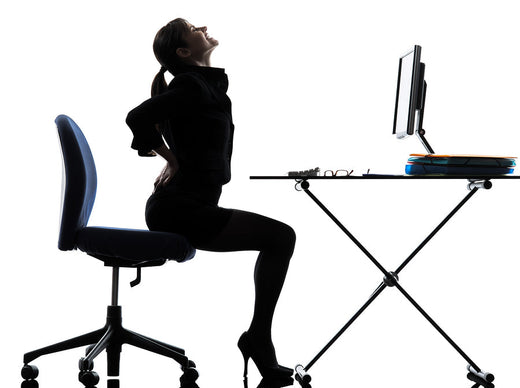 Woman sitting on the edge of a chair, experiencing pain